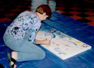 Jan Dodgins participating in a group painting project