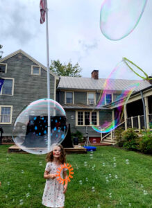 Girl playing with giant bubbles at Arts Fest